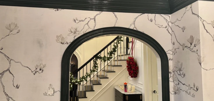 Wallpapered arch with branch pattern and dark painted trim